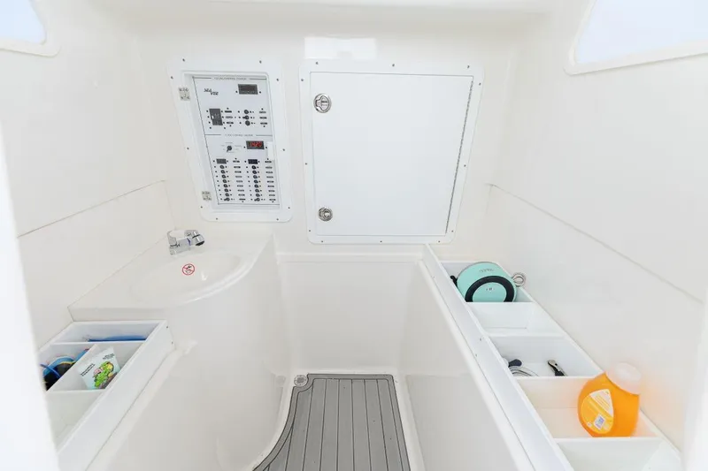 Slide: The Image of 2024 SeaVee 370Z interior with control panel, storage compartments, and sink. - 16