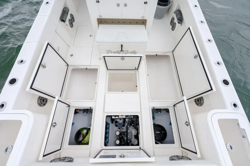 Slide: The Image of 2024 SeaVee 370Z boat deck with open storage compartments and visible engine. - 23