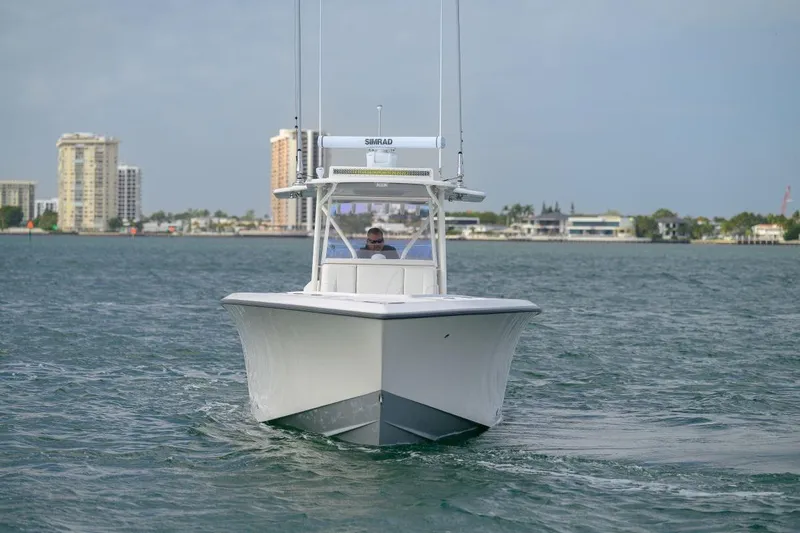 Slide: The Image of 2024 SeaVee 370Z boat cruising on water with cityscape in background. - 3