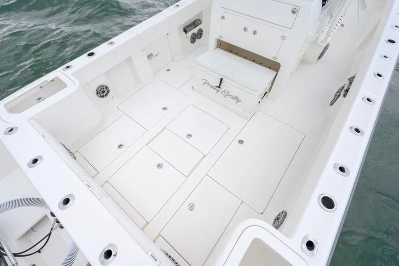 Slide: The Image of 2024 SeaVee 370Z boat deck with storage compartments and seating, on the water. - 7