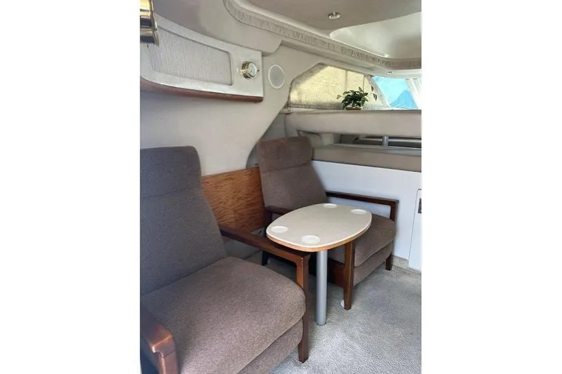 Slide: The Image of Interior of 1996 Sea Ray 400 Sedan Bridge with seating and table, featuring a potted plant. - 2