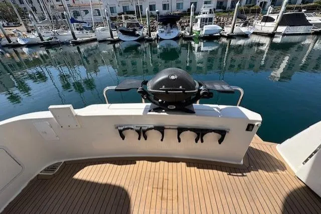 Slide: The Image of 1996 Sea Ray 400 Sedan Bridge yacht deck with teak flooring and marina view. - 35