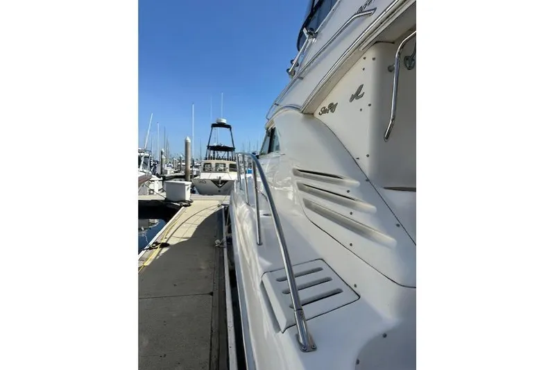 Slide: The Image of 1996 Sea Ray 400 Sedan Bridge yacht docked at marina under clear blue sky. - 42