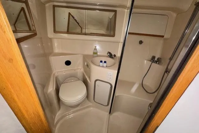 Slide: The Image of Bathroom interior of 1996 Sea Ray 400 Sedan Bridge yacht, featuring shower and sink. - 9