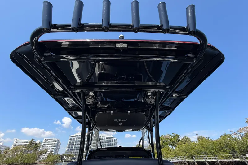 Slide: The Image of 2018 Nor-Tech 390 Sport Center Console boat with rod holders, under clear blue sky. - 14