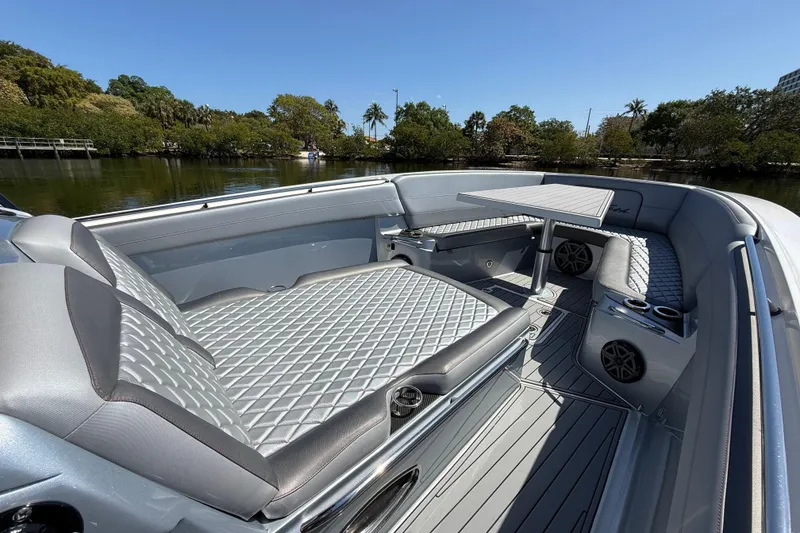 Slide: The Image of 2018 Nor-Tech 390 Sport Center Console with luxurious seating and table on calm water. - 18