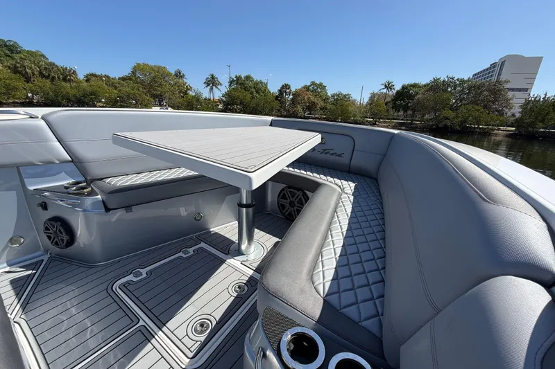 Slide: The Image of 2018 Nor-Tech 390 Sport Center Console boat interior with seating and table. - 20
