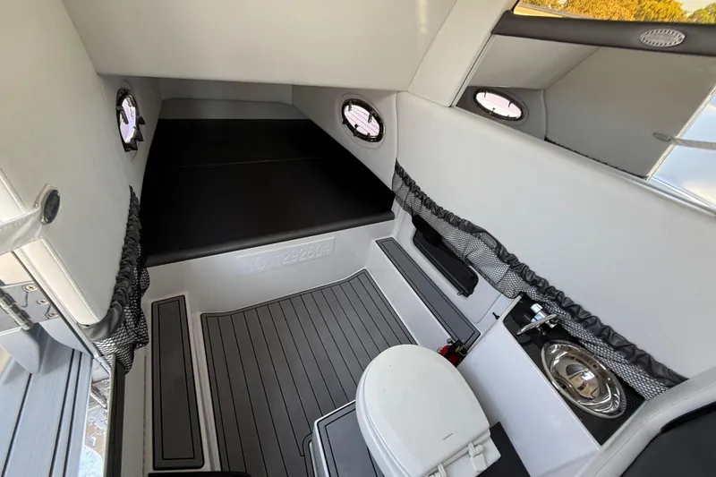 Slide: The Image of 2018 Nor-Tech 390 Sport Center Console cabin interior with bed, toilet, and sink. - 25