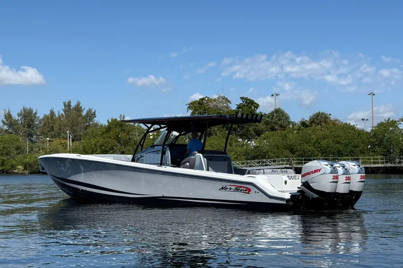 Slide: The Image of 2018 Nor-Tech 390 Sport Center Console boat on calm water, featuring triple Mercury engines. - 4