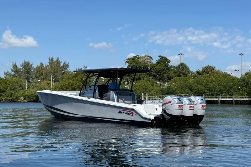 Slide: The Image of 2018 Nor-Tech 390 Sport Center Console boat with triple Mercury engines on calm water. - 5