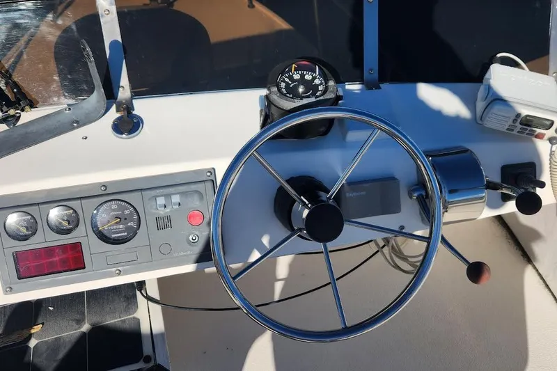 Slide: The Image of Helm of 2001 Eastern 31 Casco Bay Flybridge with steering wheel and navigation instruments. - 12