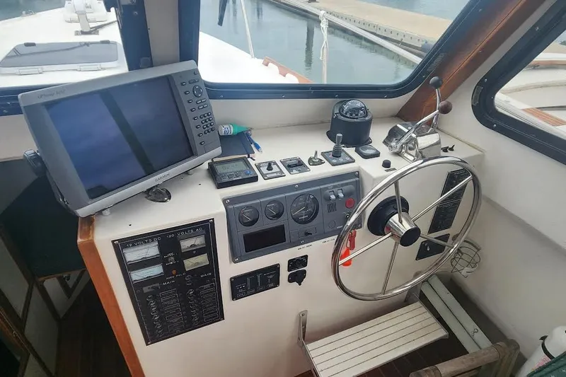 Slide: The Image of Helm of 2001 Eastern 31 Casco Bay Flybridge with navigation equipment and steering wheel. - 13