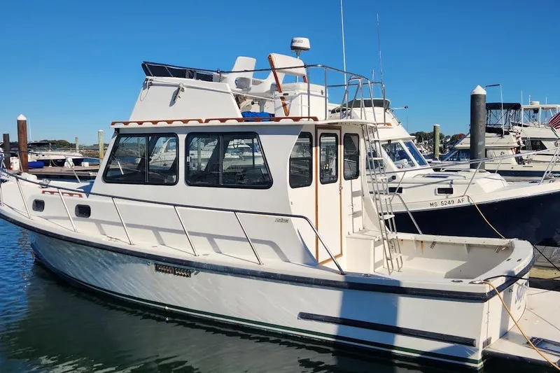 The Image of 2001 Eastern 31 Casco Bay Flybridge boat docked in marina under clear blue sky. - 1