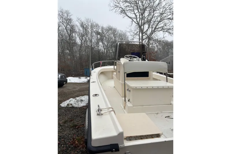 Slide: The Image of 1998 Parker 1801 Center Console boat on gravel, surrounded by trees and snow patches. - 10