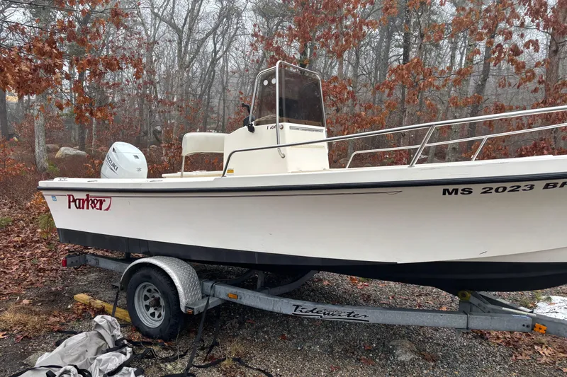 Slide: The Image of 1998 Parker 1801 Center Console boat on trailer in wooded area. - 2