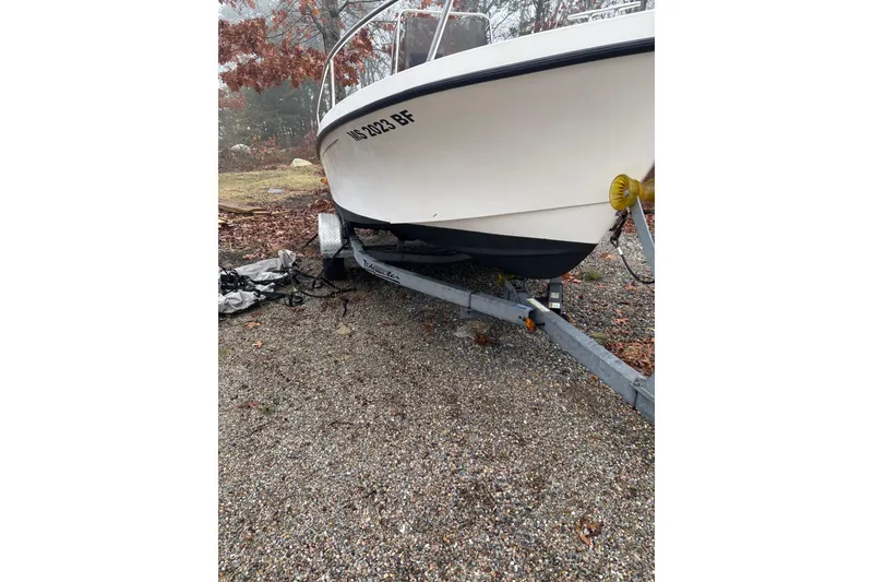 Slide: The Image of 1998 Parker 1801 Center Console boat on trailer, parked on gravel. - 8