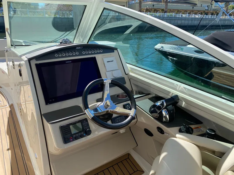 Slide: The Image of 2019 Boston Whaler 320 Vantage helm by the water. - 20