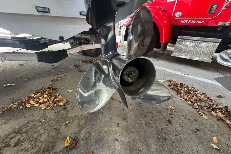 Slide: The Image of Propeller of 2023 Wellcraft 242 Fisherman boat on trailer, with red truck nearby. - 11