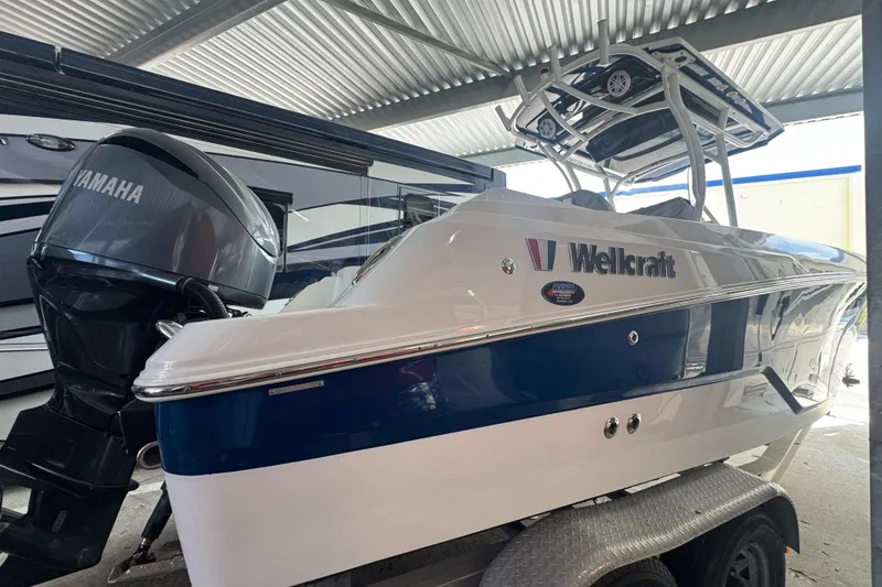 Slide: The Image of 2023 Wellcraft 242 Fisherman boat with Yamaha engine on trailer in covered area. - 16