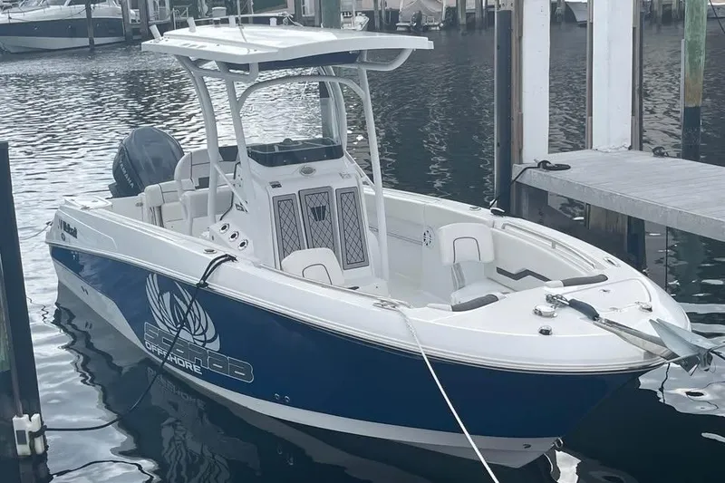 Slide: The Image of 2023 Wellcraft 242 Fisherman boat docked in marina, featuring sleek design and modern amenities. - 2