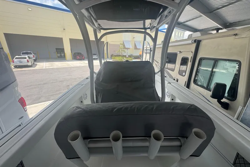 Slide: The Image of 2023 Wellcraft 242 Fisherman boat interior with rod holders, parked in a lot. - 25