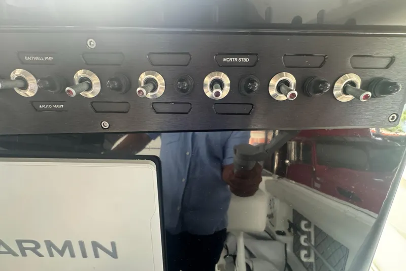 Slide: The Image of Control panel of 2023 Wellcraft 242 Fisherman boat with switches and Garmin display. - 32