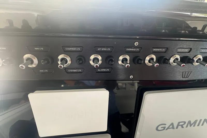Slide: The Image of Control panel of 2023 Wellcraft 242 Fisherman boat with labeled switches and Garmin display. - 33