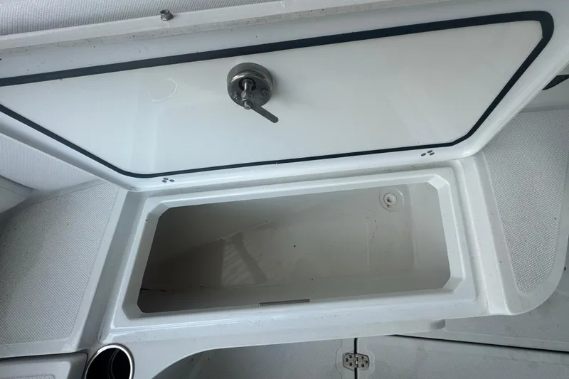 Slide: The Image of Open storage compartment on 2023 Wellcraft 242 Fisherman boat, featuring a secure latch. - 43