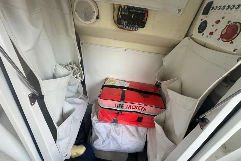 Slide: The Image of Interior of 2023 Wellcraft 242 Fisherman boat with life jackets and storage compartments. - 53