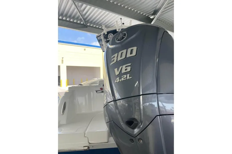 Slide: The Image of 2023 Wellcraft 242 Fisherman boat rear view in storage, featuring motor and warning label. - 8