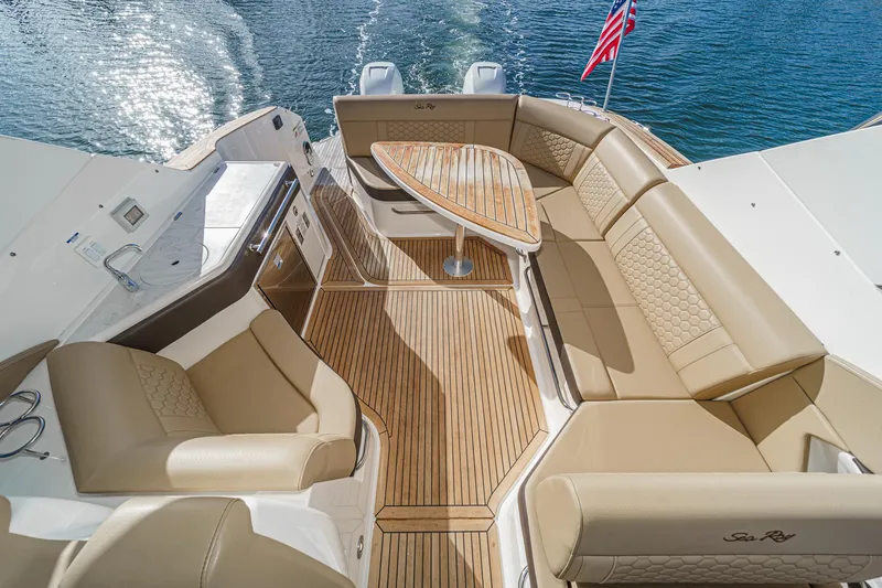Slide: The Image of 2023 Sea Ray Sundancer 320 OB boat interior with tan seating and wooden deck. - 15