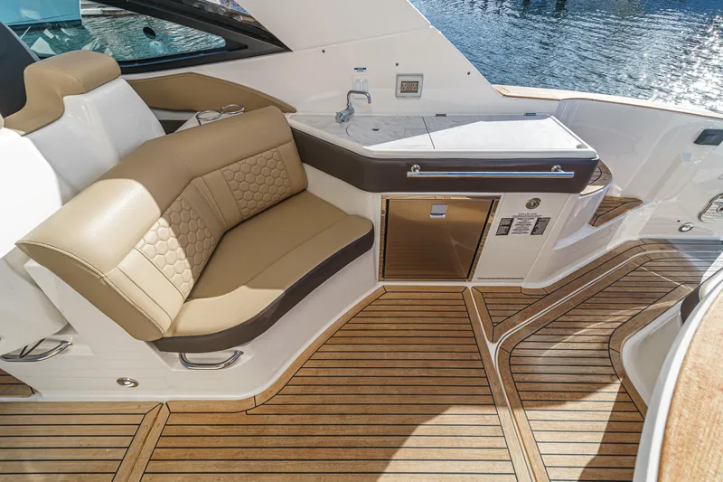 Slide: The Image of 2023 Sea Ray Sundancer 320 OB interior with tan seating and wooden flooring. - 17