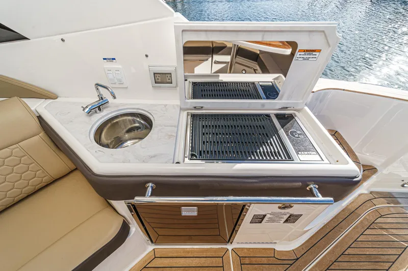 Slide: The Image of 2023 Sea Ray Sundancer 320 OB boat kitchenette with sink and grill on deck. - 18