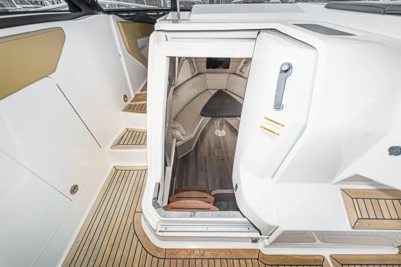 Slide: The Image of 2023 Sea Ray Sundancer 320 OB cabin entrance with wooden steps and sleek interior design. - 30