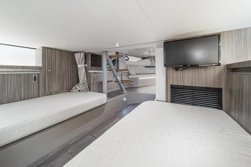 Slide: The Image of 2023 Sea Ray Sundancer 320 OB interior cabin with modern design, featuring beds and a TV. - 37