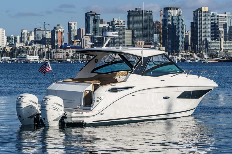 Slide: The Image of 2023 Sea Ray Sundancer 320 OB yacht on water with city skyline backdrop. - 4