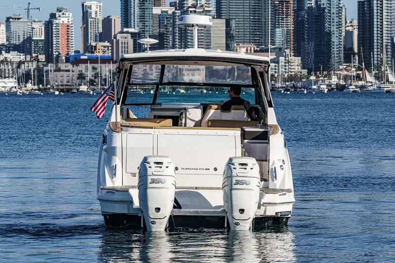Slide: The Image of 2023 Sea Ray Sundancer 320 OB cruising in urban harbor with city skyline backdrop. - 5