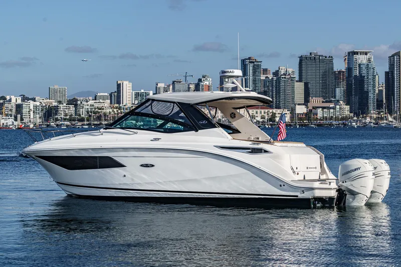 Slide: The Image of 2023 Sea Ray Sundancer 320 OB boat on water with city skyline background. - 6
