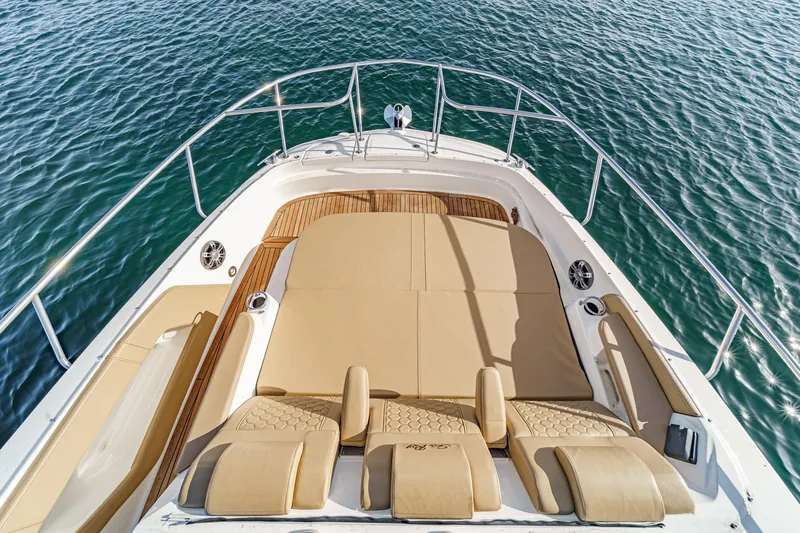 Slide: The Image of 2023 Sea Ray Sundancer 320 OB boat deck with tan seating on open water. - 8