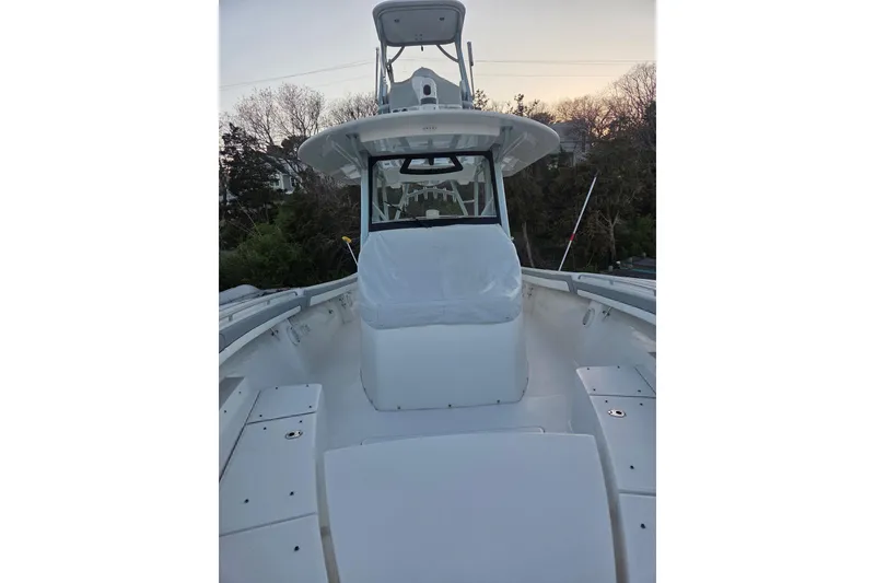 Slide: The Image of 2019 Regulator 41 boat deck with covered seating, surrounded by trees at sunset. - 19