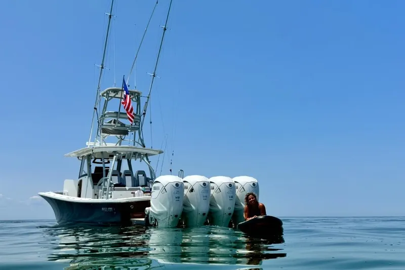 The Image of 2019 Regulator 41 boat with four engines on calm water, clear blue sky. - 2