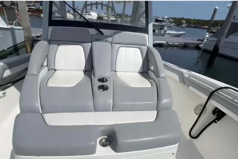 Slide: The Image of 2019 Regulator 41 boat with comfortable gray and white seating at a marina. - 6