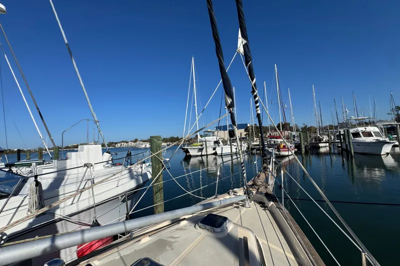 Slide: The Image of Sailboats docked at a marina, featuring a 1991 Island Packet Yachts 38 under clear blue skies. - 15