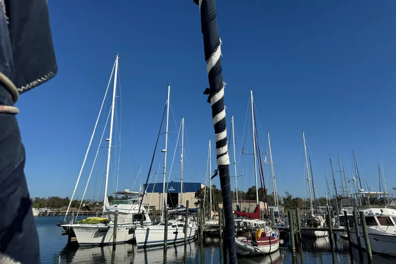 Slide: The Image of Sailboats docked at a marina under clear blue skies, featuring a 1991 Island Packet Yachts 38. - 17