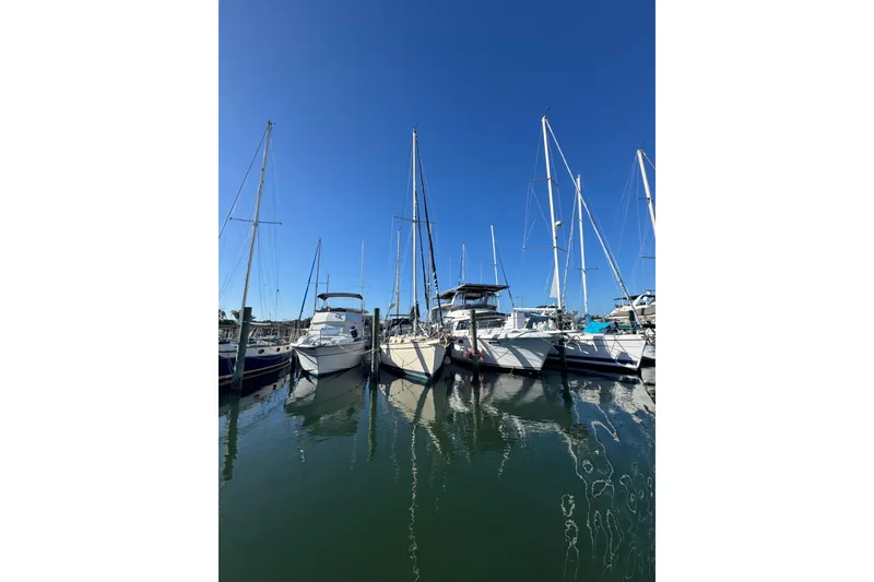 Slide: The Image of Sailboats docked at marina under clear blue sky, featuring 1991 Island Packet Yachts 38. - 2