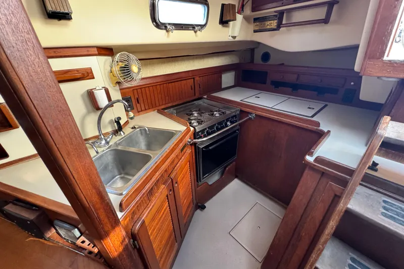 Slide: The Image of 1991 Island Packet Yachts 38 interior galley with wood cabinetry and stainless steel sink. - 22