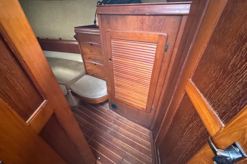 Slide: The Image of Interior cabin of 1991 Island Packet Yachts 38, featuring wooden cabinetry and seating. - 23