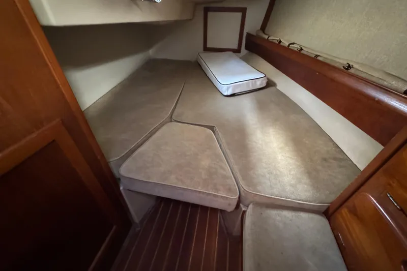 Slide: The Image of Interior cabin of 1991 Island Packet Yachts 38, featuring cushioned seating and wooden accents. - 24