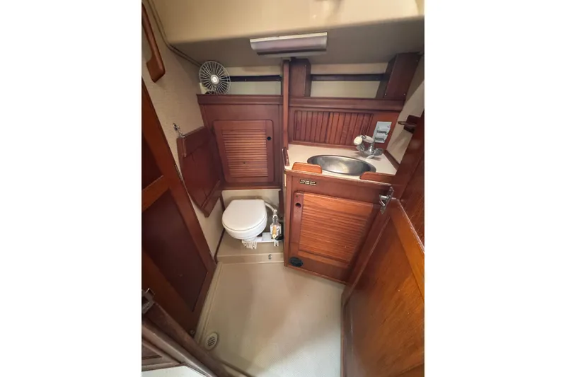 Slide: The Image of 1991 Island Packet Yachts 38 bathroom with wooden cabinetry and compact design. - 27