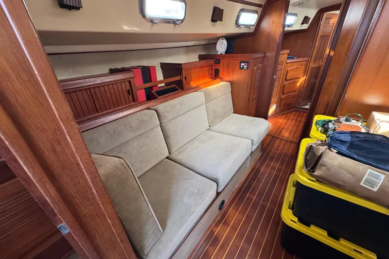 Slide: The Image of Interior of 1991 Island Packet Yachts 38, featuring cozy seating and wooden cabinetry. - 28